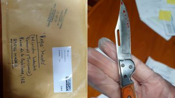Imagen del sobre y la navaja en la mano enguantada de la policía científica