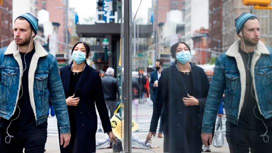 Personas con y sin mascarilla caminan por una calle de Nueva York Personas con y sin mascarilla caminan por una calle de Nueva York