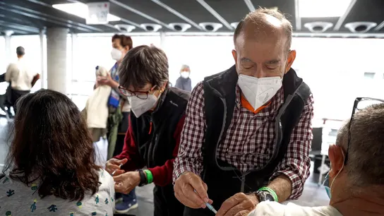 Dos personas reciben sus respectivas dosis de vacuna en el Wizink Center de Madrid. Dos personas reciben sus respectivas dosis de vacuna en el Wizink Center de Madrid.