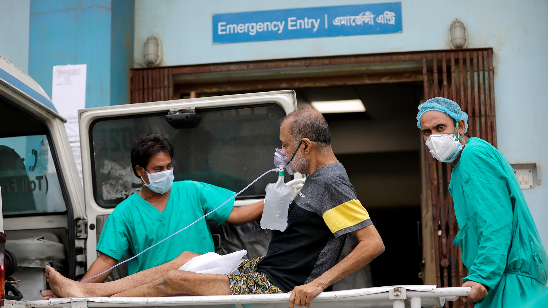 Dos sanitarios atienden a un paciente con COVID-19 en el hospital de Kolkata, en La India