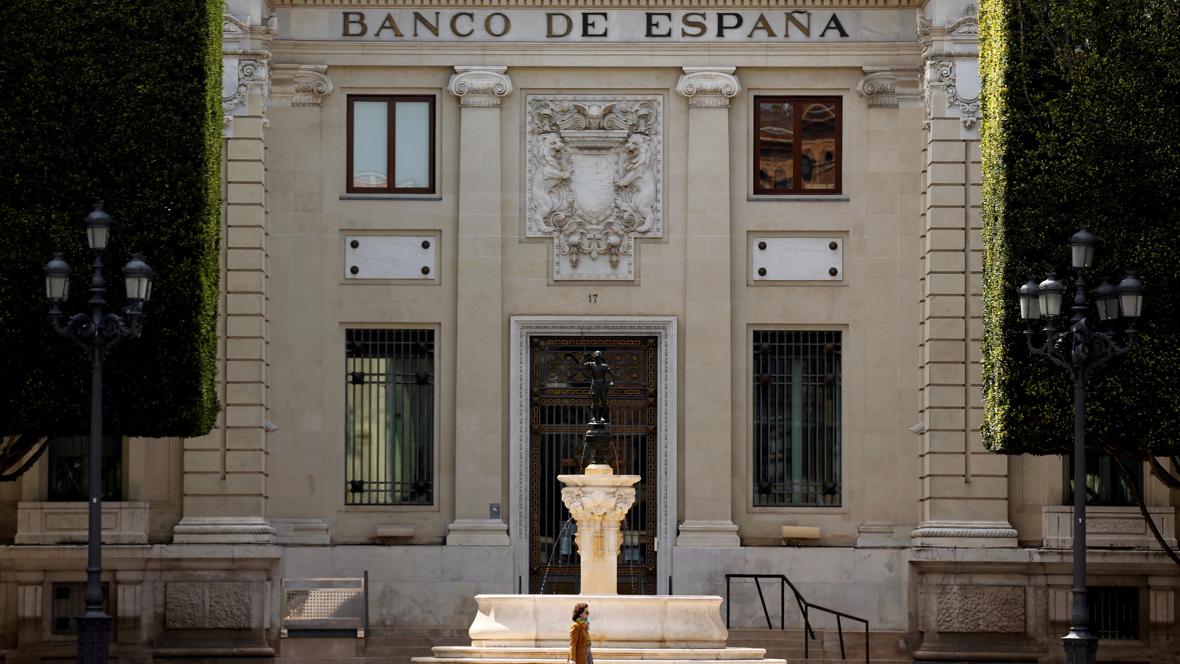 Una mujer pasea frente a la fachada de la sede del Banco de España en Sevilla