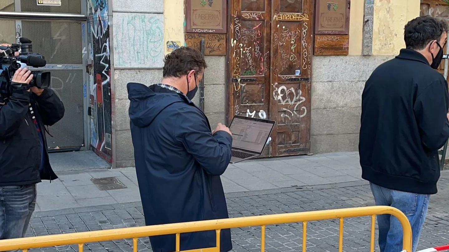 Un votante con el ordenador mientras espera su turno para entrar en el colegio electoral Un votante con el ordenador mientras espera su turno para entrar en el colegio electoral