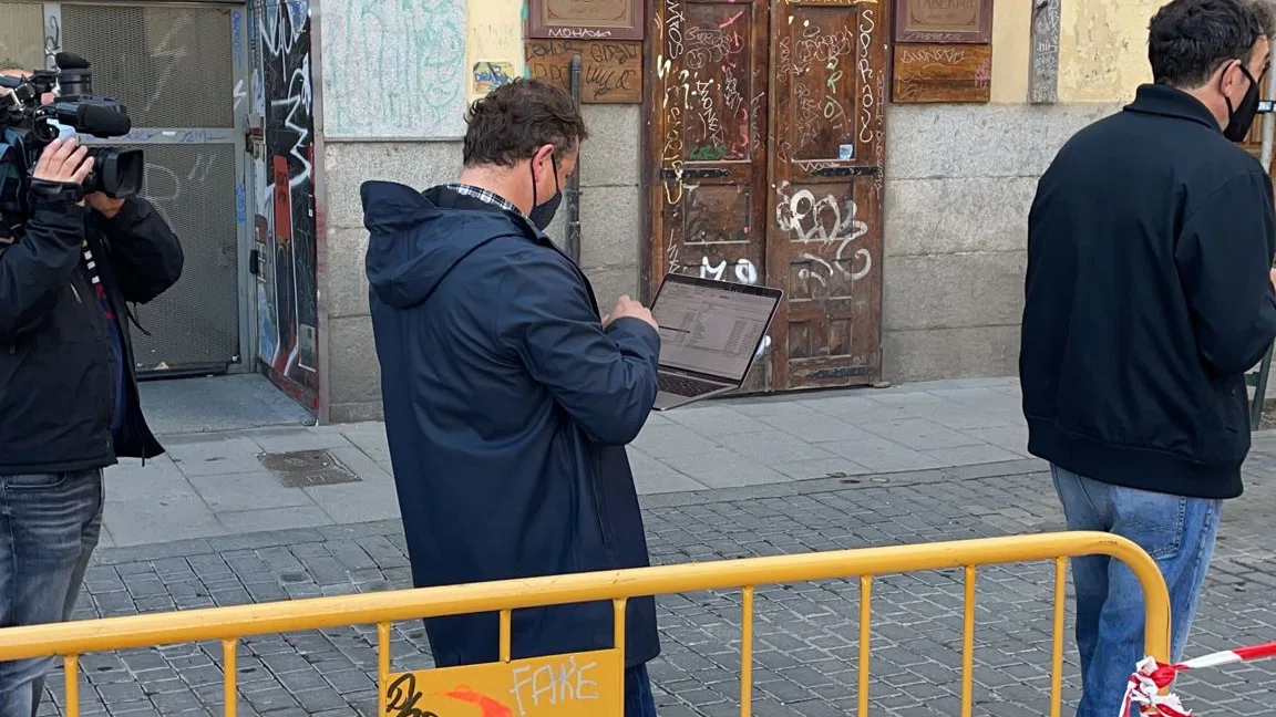 Un votante con el ordenador mientras espera su turno para entrar en el colegio electoral