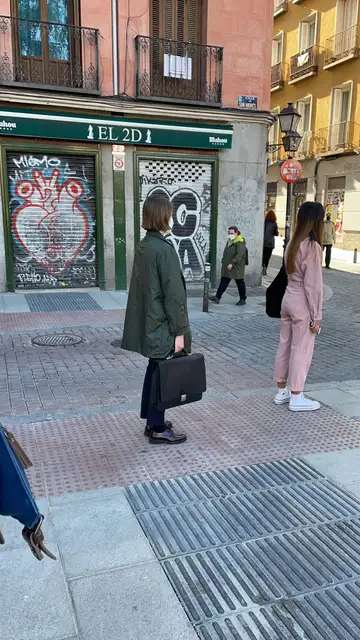Una mujer espera en la cola para votar con un maletín en la mano Una mujer espera en la cola para votar con un maletín en la mano