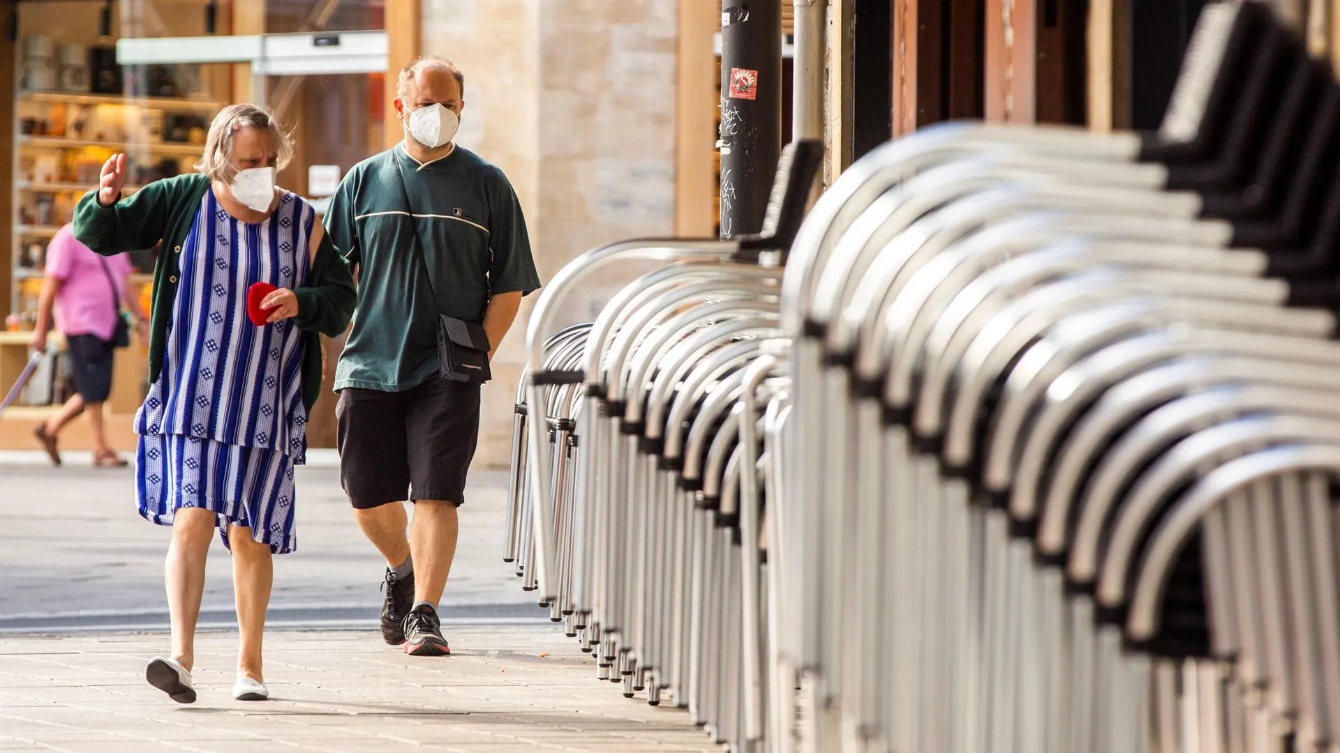 Dos personas con mascarilla por la calle