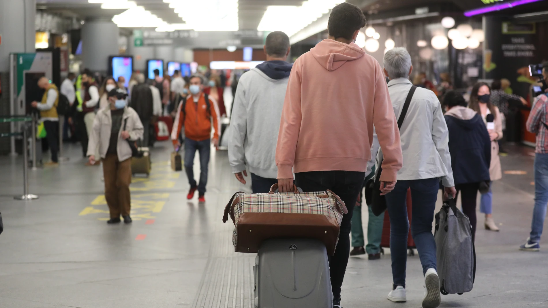 Varias personas caminan con su equipaje por la estación de Madrid - Puerta de Atocha, a 14 de mayo de 2021, en Madrid 