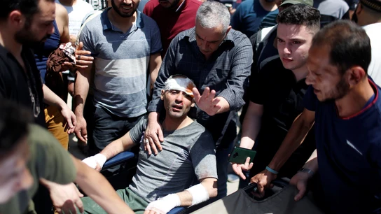 Los equipos de rescate ayudan a un hombre después de sacarlo de los escombros de un edificio en el lugar de los ataques aéreos israelíes en Gaza Gaza e Israel
