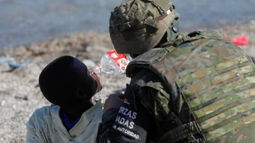 Un soldado asistiendo a un inmigrante en Ceuta