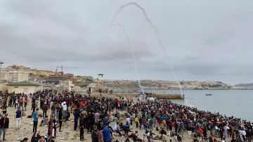 Cientos de personas esperan en la playa de la localidad de Fnideq (Castillejos) para cruzar los espigones de Ceuta este martes
