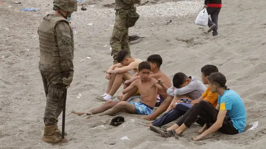 Miembros del Ejército de Tierra vigilan a un grupo de inmigrantes menores que han logrado cruzar uno de los espigones fronterizos de Ceuta  Miembros del Ejército de Tierra vigilan a un grupo de inmigrantes menores que han logrado cruzar uno de los espigones fronterizos de Ceuta