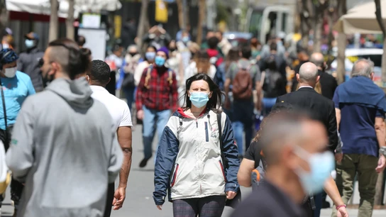 Personas con mascarilla caminan por la Gran Vía madrileña Personas con mascarilla caminan por la Gran Vía madrileña