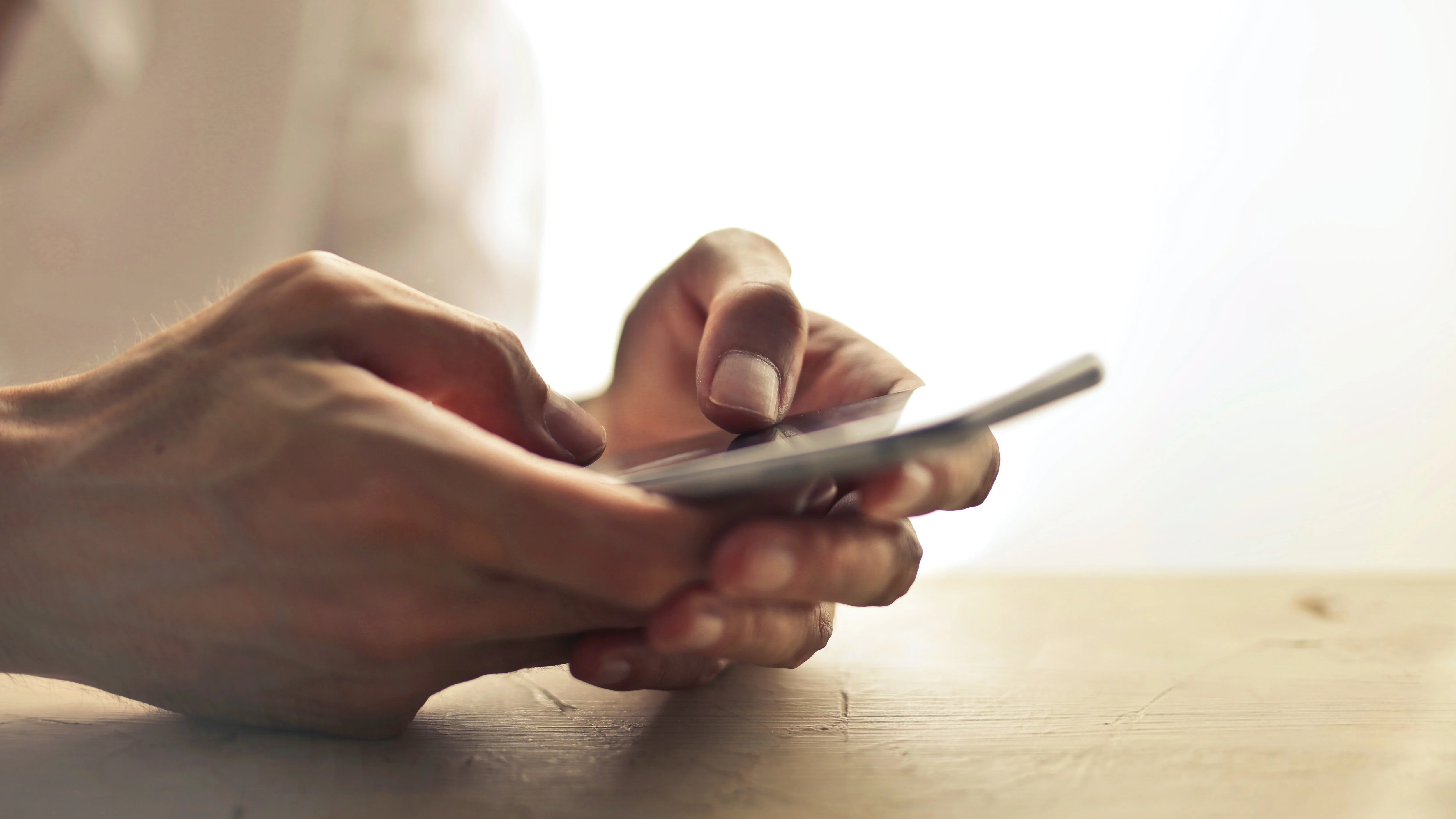 Una persona sostiene el teléfono móvil entre las manos