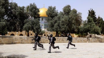 Agentes de la policía de Israel corren ante la explanada de la mezquita de Al-Aqsa.