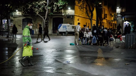 Un hombre riega una calle de Barcelona, una semana después del fin del estado de alarma, en Barcelona Un hombre riega una calle de Barcelona, una semana después del fin del estado de alarma, en Barcelona