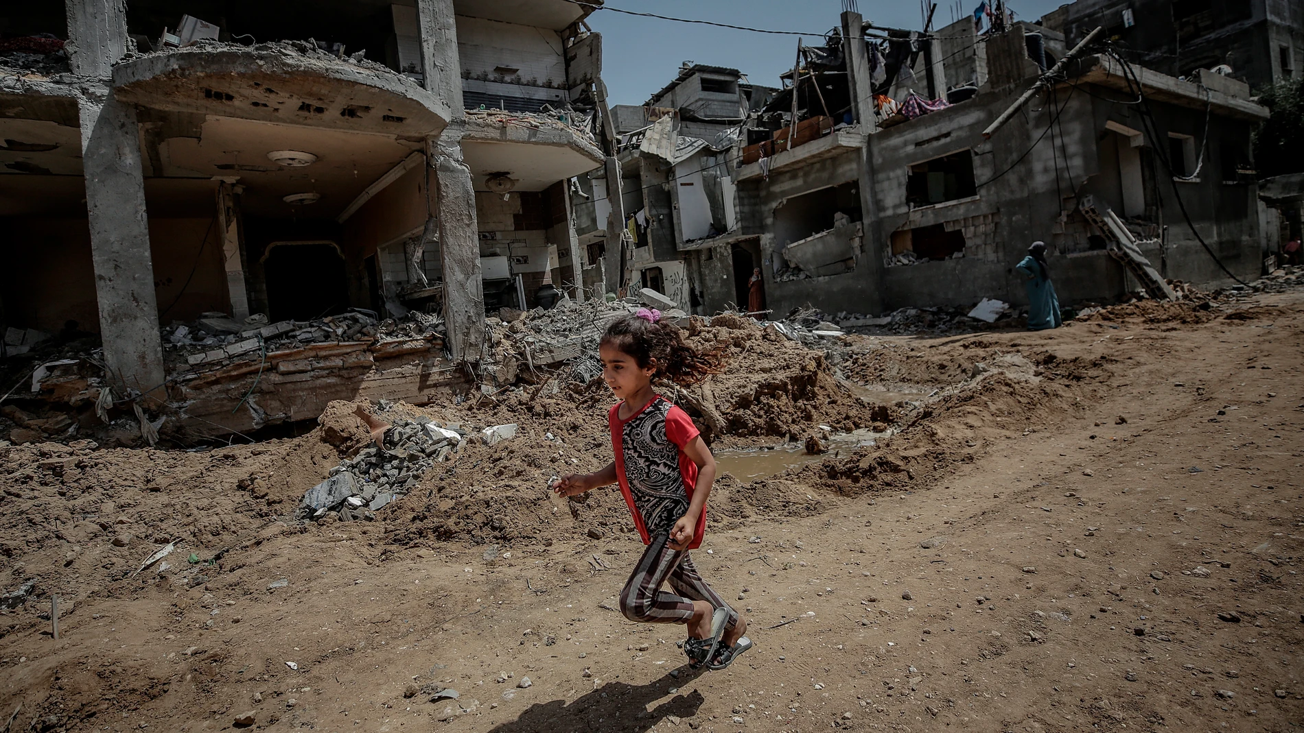 Una niña palestina corre cerca a la destruida casa de su familia, en Beit Hanun, Gaza.