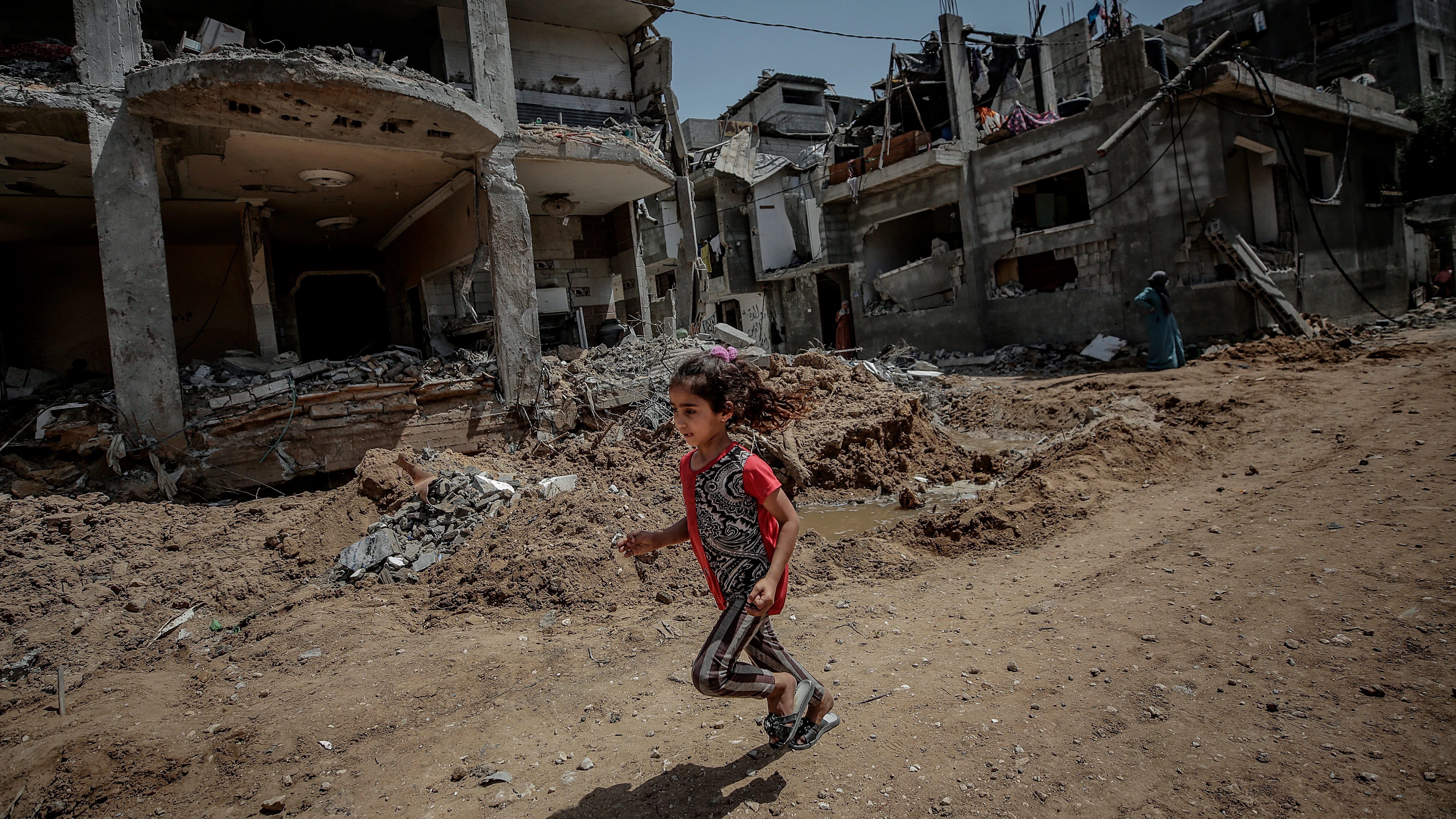 Una niña palestina corre cerca a la destruida casa de su familia, en Beit Hanun, Gaza