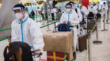 Viajeros procedentes de China con trajes de protección en la terminal T4 del Aeropuerto de Barajas