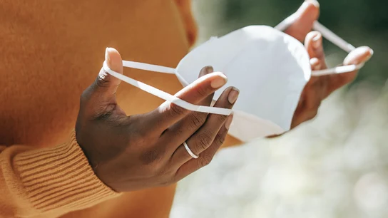 Una mujer sujeta una mascarilla en una imagen de archivo Una mujer sujeta una mascarilla en una imagen de archivo
