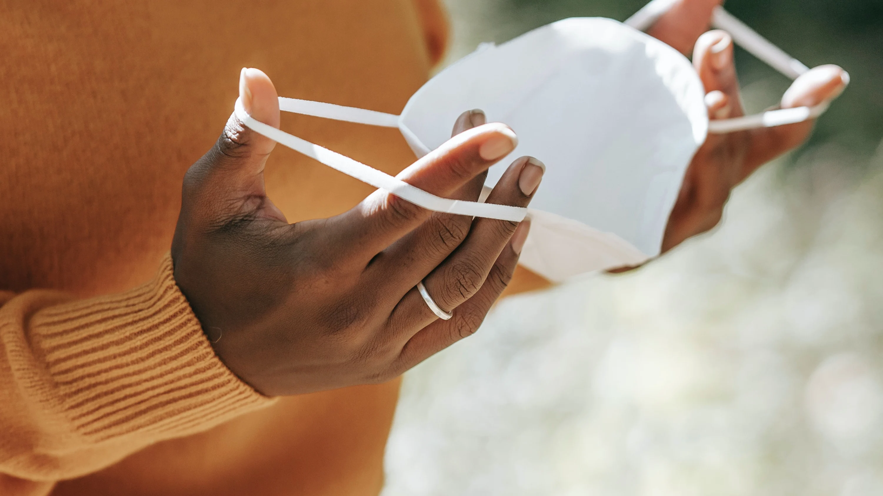 Una mujer sujeta una mascarilla en una imagen de archivo