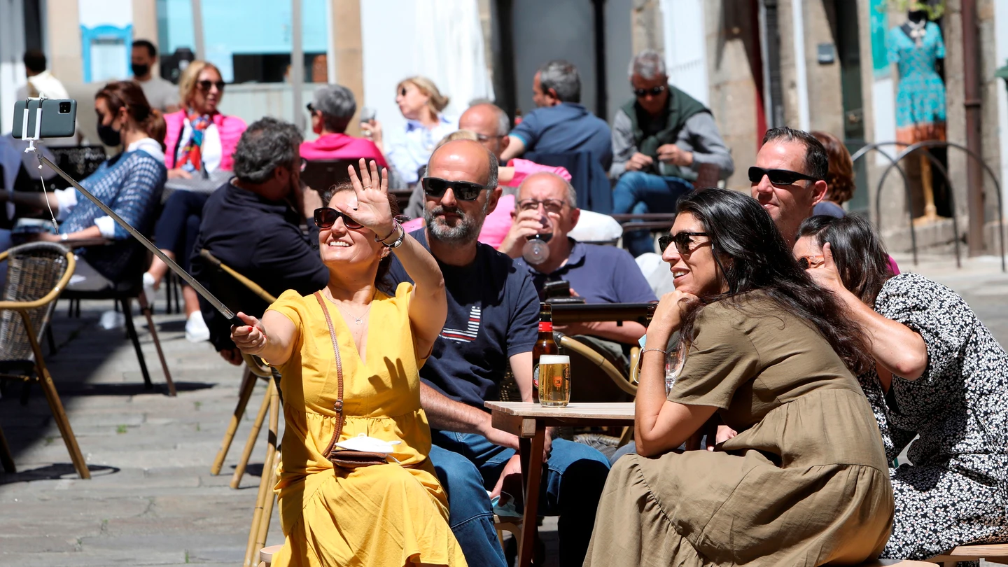 Unos turistas disfrutan este sábado en una terraza en Santiago de Compostela Unos turistas disfrutan este sábado en una terraza en Santiago de Compostela