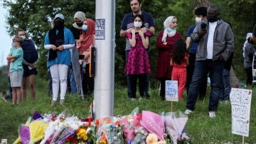 Un grupo de personas se reúne en el memorial creado en homenaje de la familia asesinada
