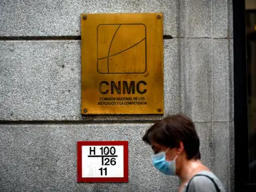 Una mujer pasa por el edificio de la CNMC, en Madrid