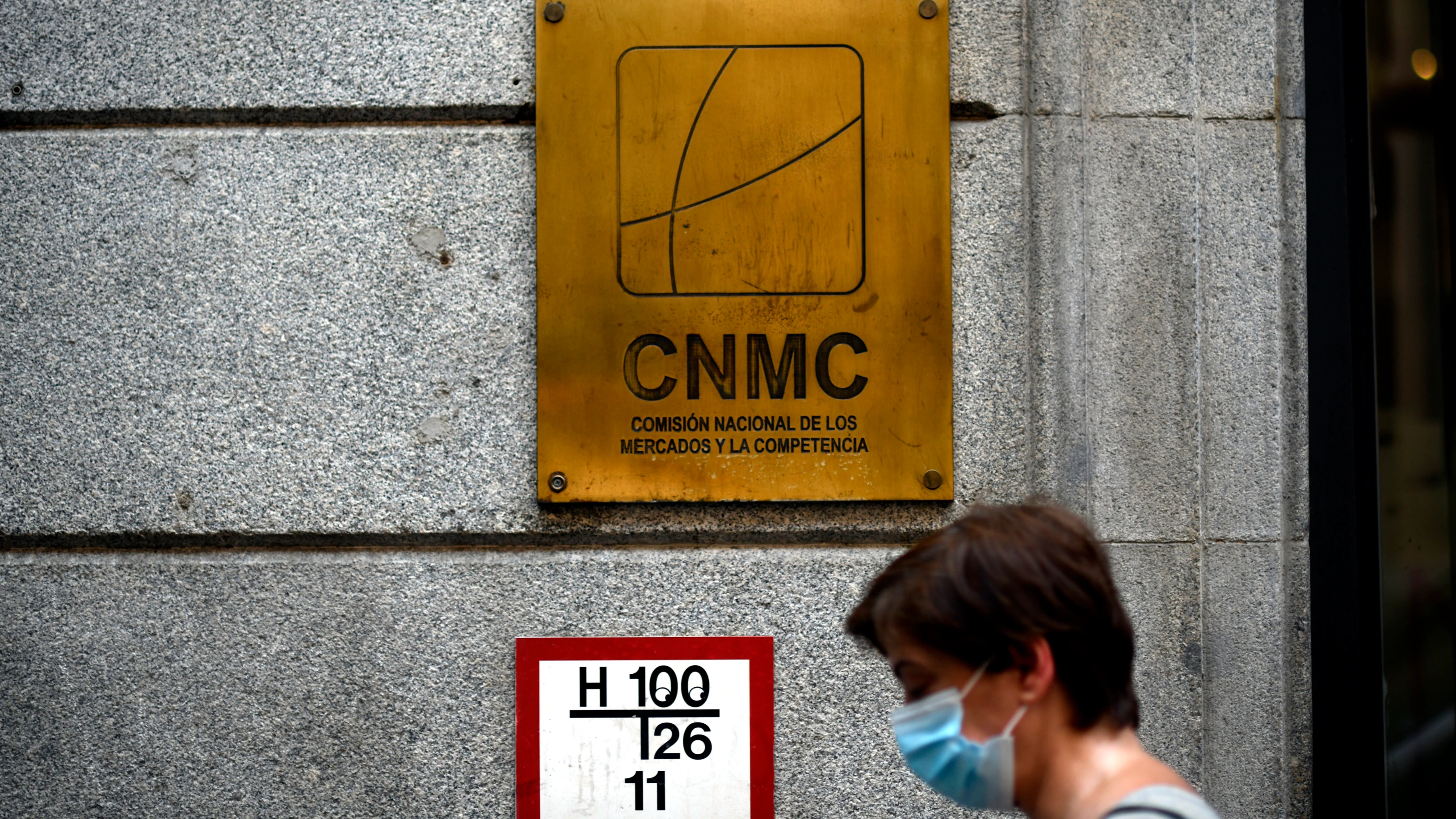 Una mujer pasa por el edificio de la CNMC, en Madrid 