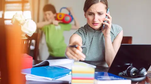 Mujer teletrabajando con sus hijos en casa Mujer teletrabajando con sus hijos en casa