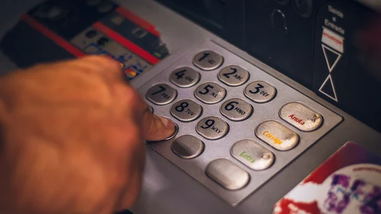 Una persona saca dinero en un cajero automático de un banco Una persona saca dinero en un cajero automático de un banco
