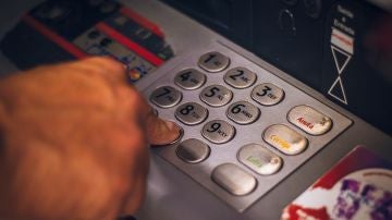 Una persona saca dinero en un cajero automático de un banco