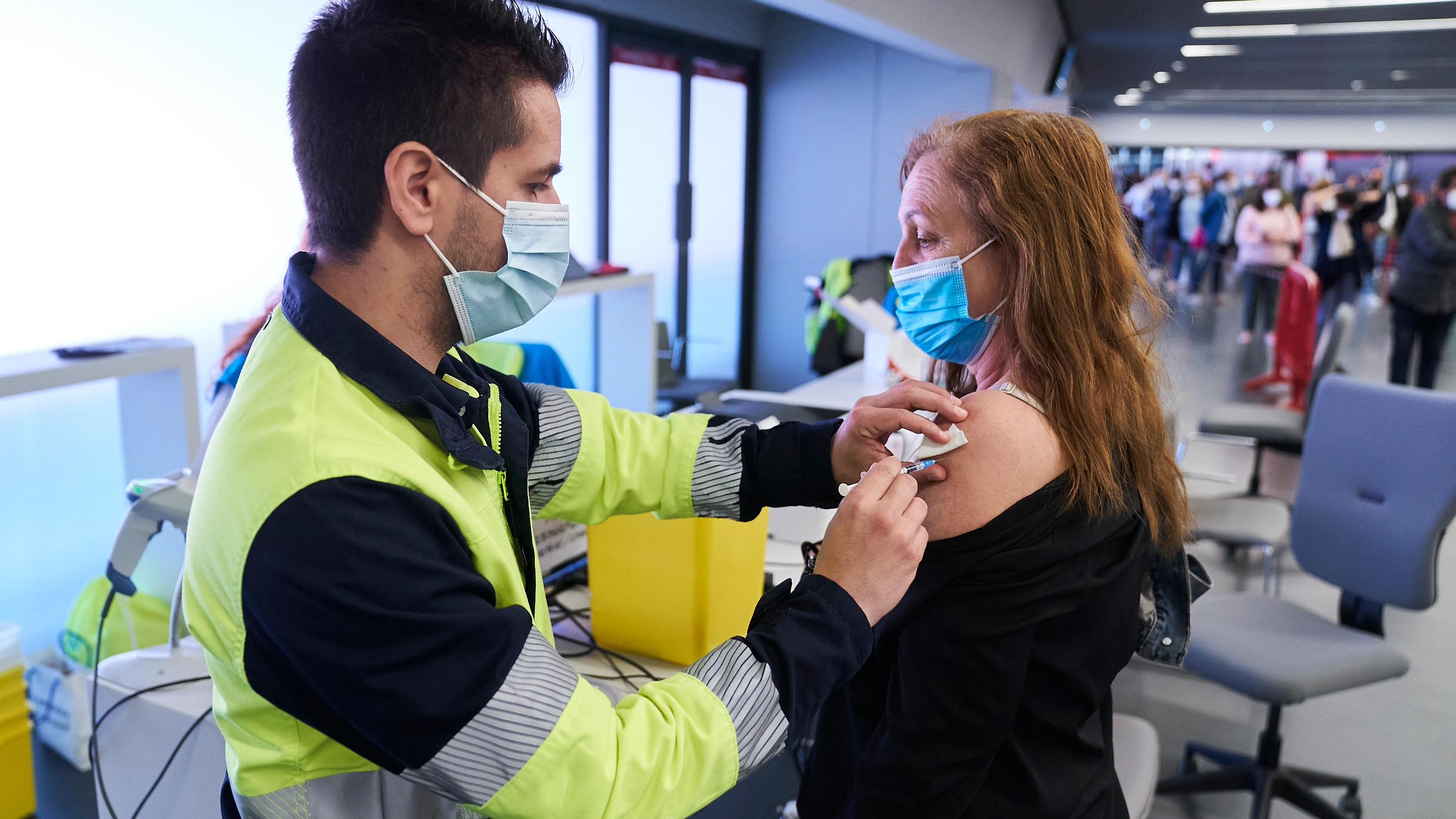 Un sanitario vacuna a una mujer con la dosis de Pfizer, en el Wanda Metropolitano