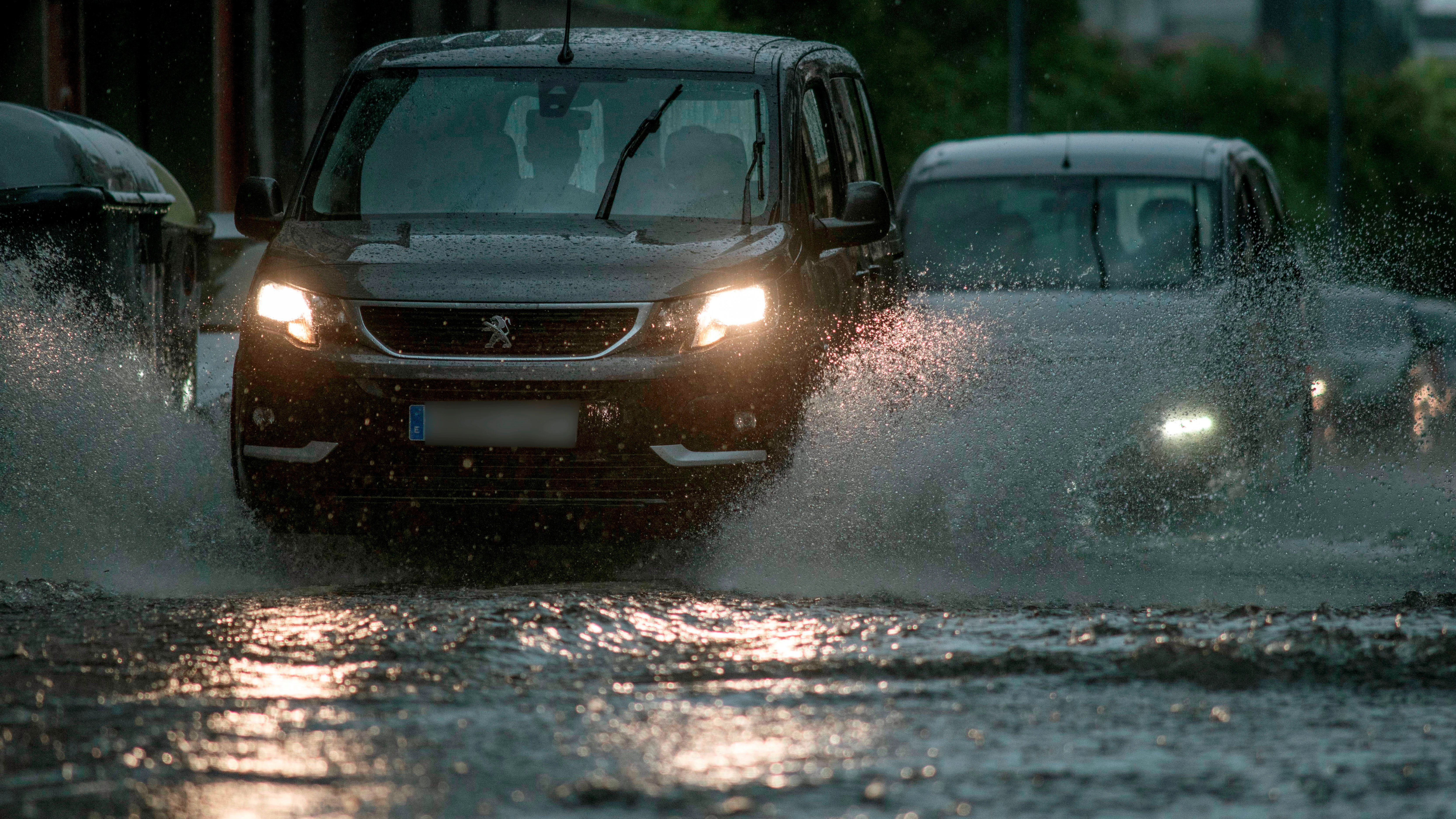 Vehículos circulan bajo una intensa lluvia en Orense.