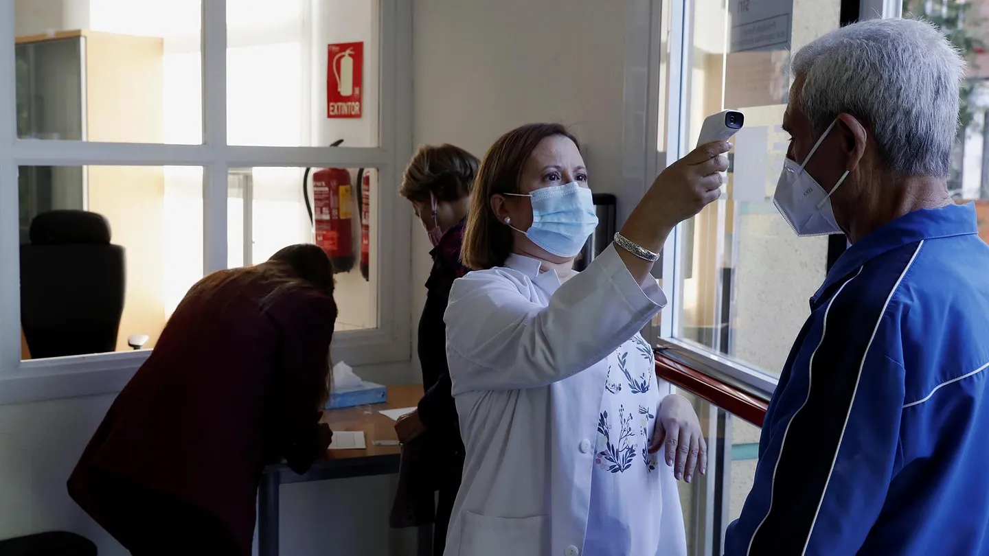 Una mujer toma la temperatura a un hombre Una mujer toma la temperatura a un hombre