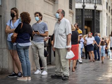 Varias personas hacen cola frente al Banco de España de València para cambiar pesetas a euros 
