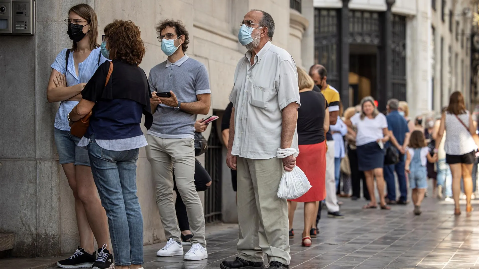 Varias personas hacen cola frente al Banco de España de València para cambiar pesetas a euros 