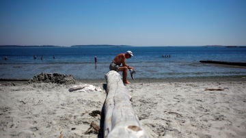 Un hombre descansa en Willow's Beach durante la "cúpula de calor" que se cierne actualmente sobre la Columbia Británica y Alberta