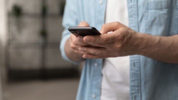 Un joven utiliza su teléfono móvil.