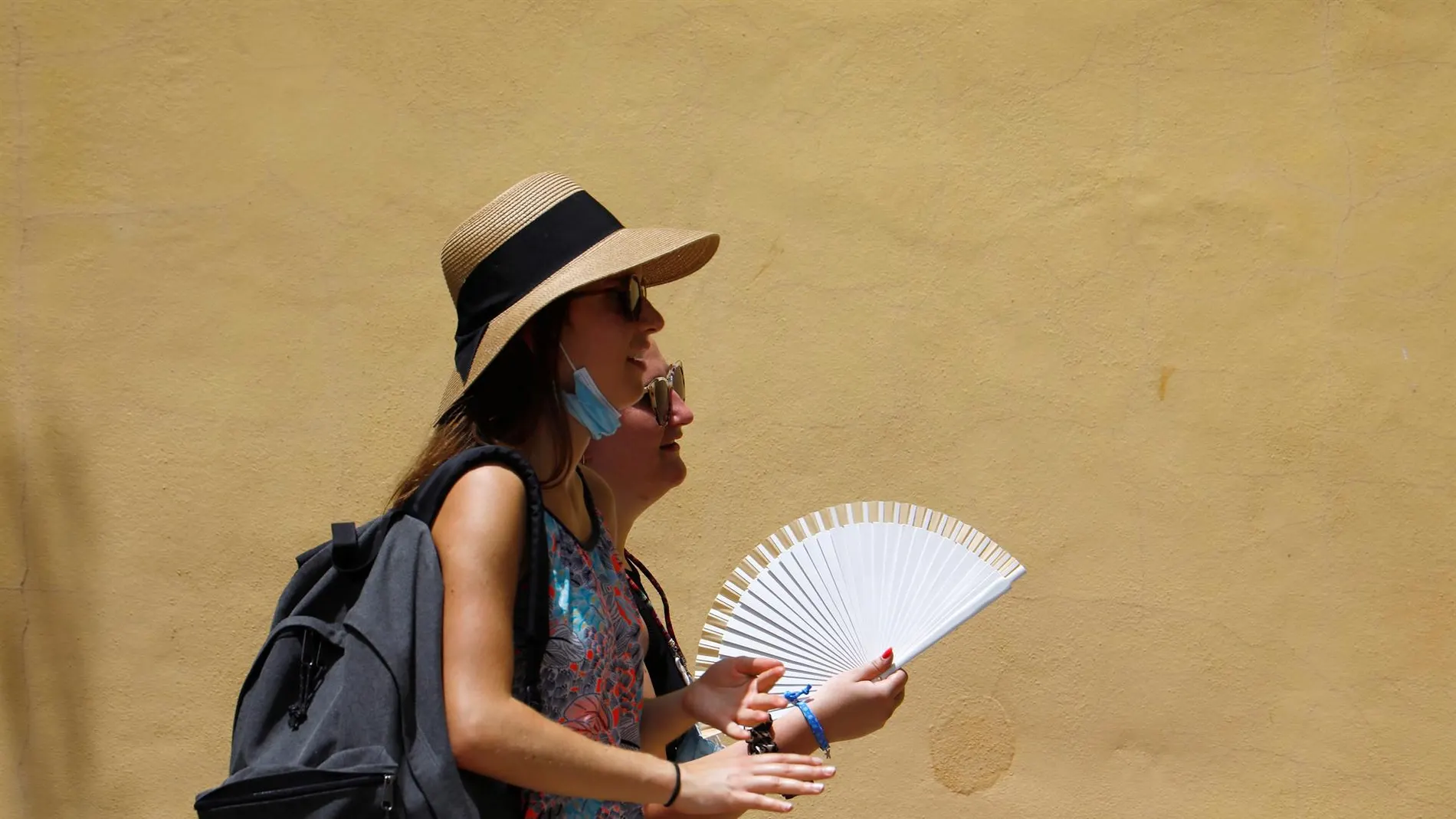 Varias personas se protegen del sol y el calor que se registra hoy en Córdoba