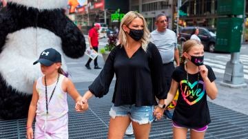 Personas con mascarilla caminan en Times Square en Nueva York