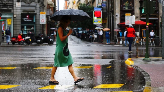 Una mujer se protege de la lluvia en el centro de Madrid EFE