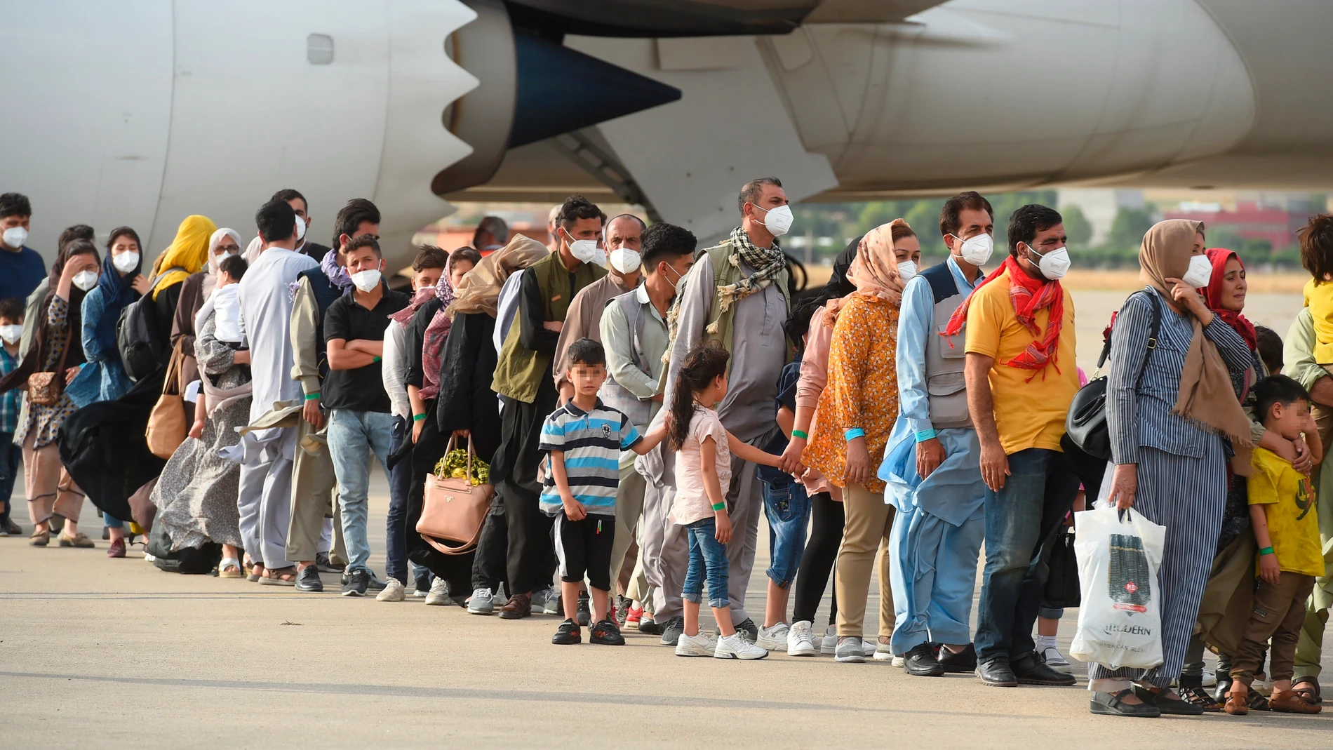 Algunas de las 260 personas procedentes de Afganistán que llegaron este lunes en un avión a la base aérea de Torrejón de Ardoz
