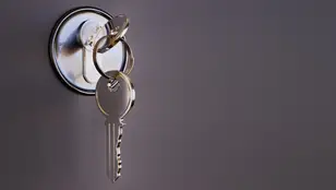 Imagen de archivo de varias llaves en la cerradura de una puerta.