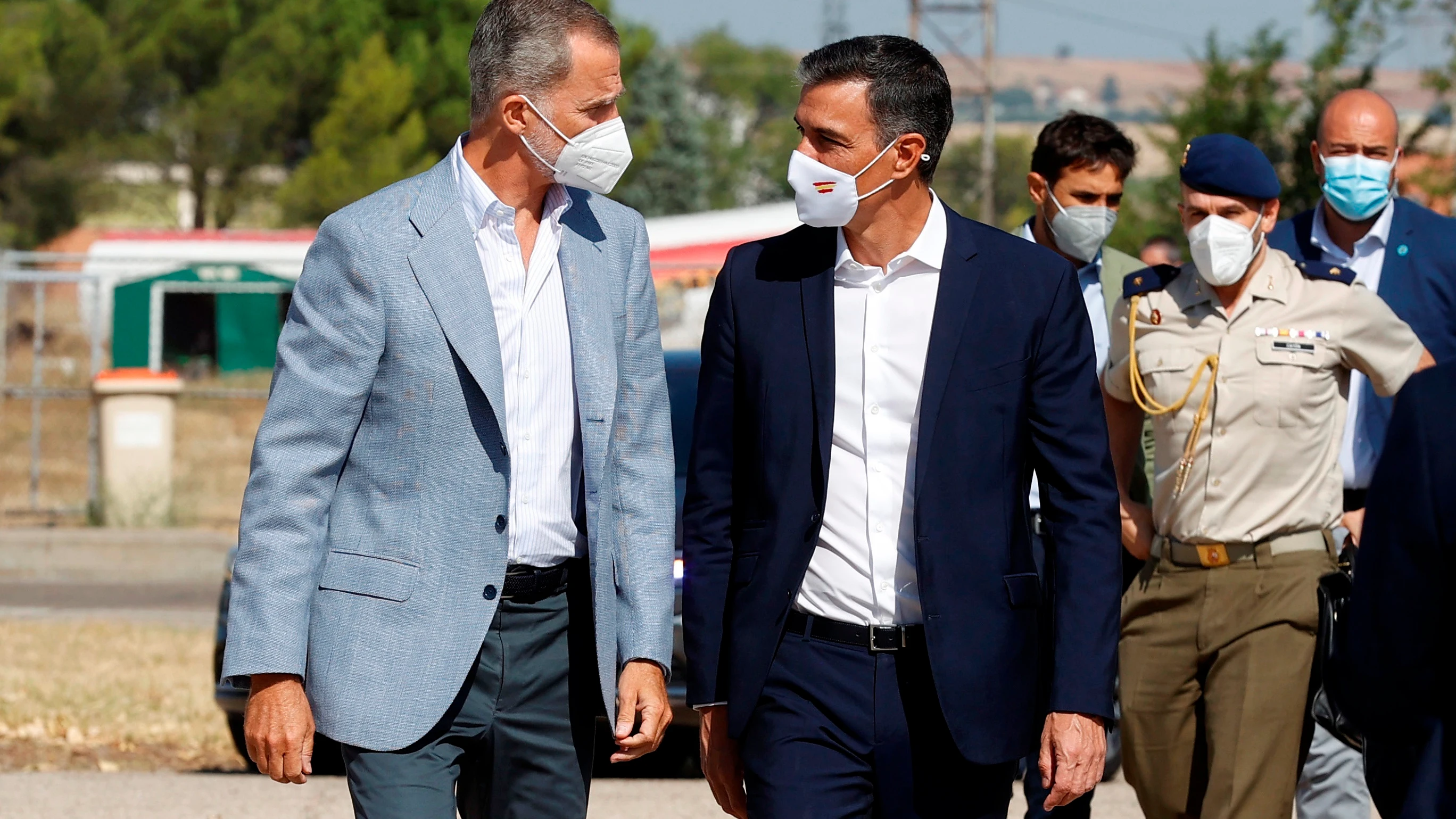 El rey Felipe VI y Pedro Sánchez conversan durante su visita al centro de acogida temporal instalado en la base de Torrejón de Ardoz