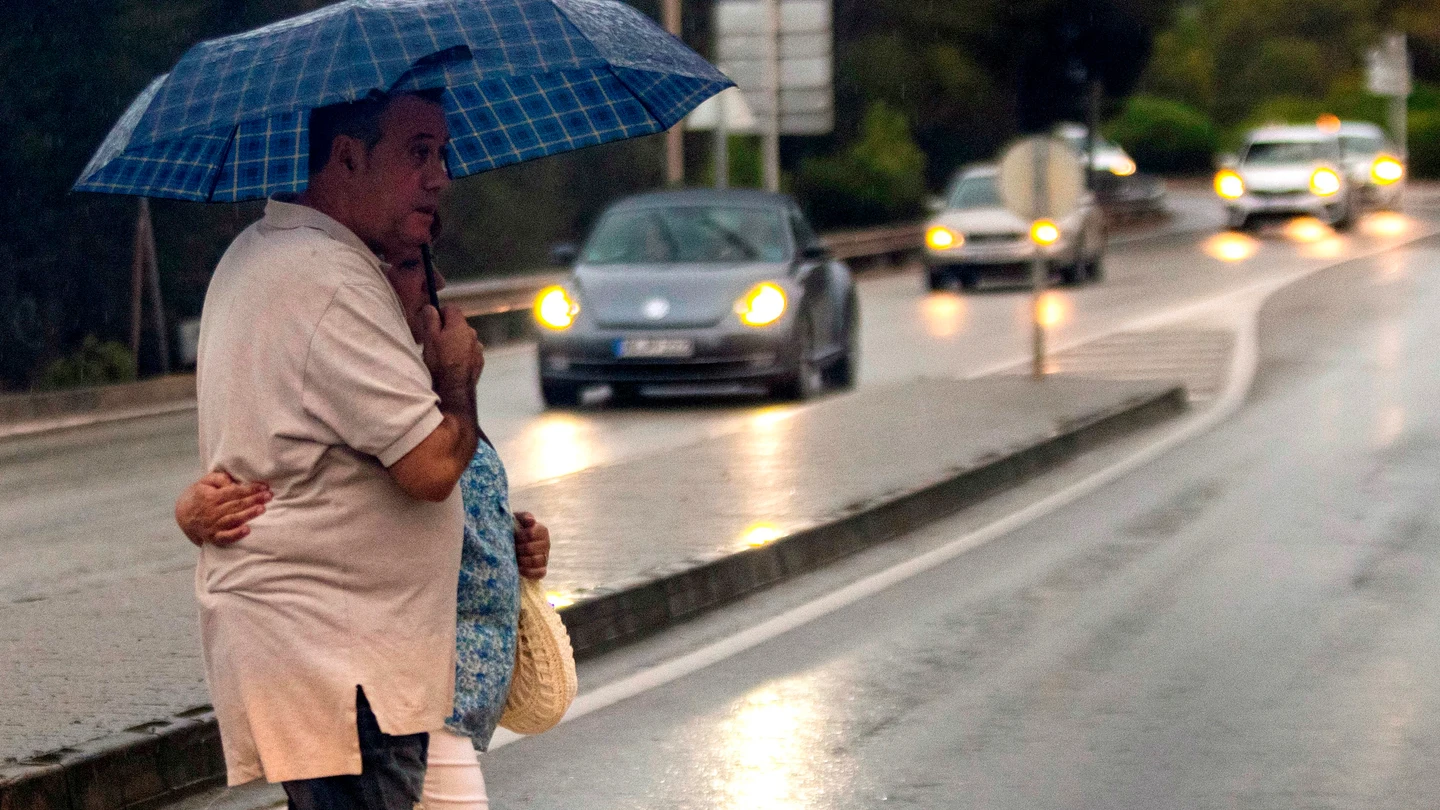 Una pareja pasea bajo un paraguas por las calles de Palma de Mallorca, este lunes. Una pareja pasea bajo un paraguas por las calles de Palma de Mallorca, este lunes.