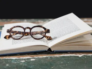 Gafas sobre libro abierto Gafas sobre libro abierto