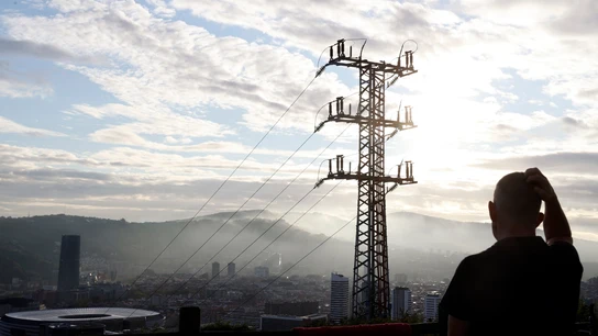 Una persona observa el cableado con el que red eléctrica transporta la energía sobre la ciudad de Bilbao. Luz