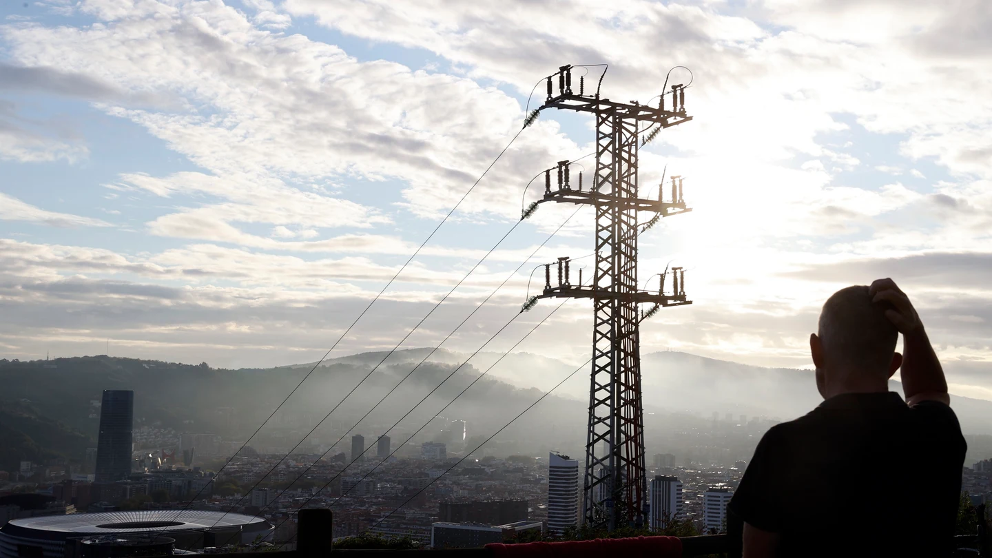 Una persona observa el cableado con el que red eléctrica transporta la energía sobre la ciudad de Bilbao. Luz