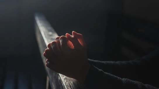 Una persona reza en una iglesia Una persona reza en una iglesia