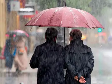 Imagen de dos personas protegiéndose de la lluvia con un paraguas