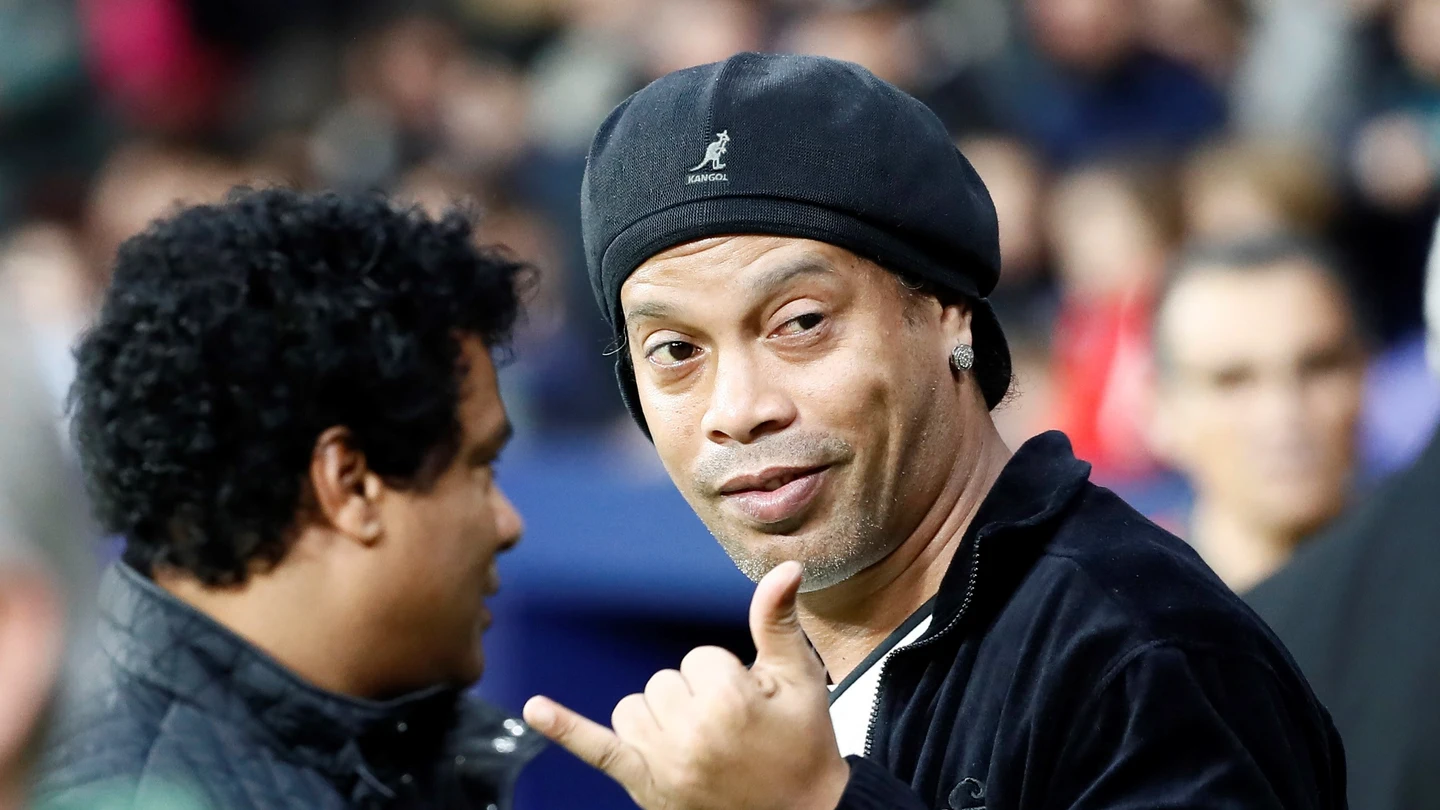 El exfutbolista brasileño Ronaldinho saluda durante el calentamiento del encuentro benéfico que se va a disputar en el estadio Wanda Metropolitano entre un combinado de Leyendas de la Selección Española y el equipo Goldstandard Estrellas del Mundo. El dinero recaudado se destinará a la lucha contra la ELA y al desarrollo del fútbol en silla de ruedas. El exfutbolista brasileño Ronaldinho saluda durante el calentamiento del encuentro benéfico que se va a disputar en el estadio Wanda Metropolitano entre un combinado de Leyendas de la Selección Española y el equipo Goldstandard Estrellas del Mundo. El dinero recaudado se destinará a la lucha contra la ELA y al desarrollo del fútbol en silla de ruedas.